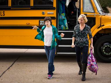 Christy Zartler helps her daughter Kara Zartler off of the school bus in front of her...