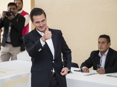 Mexican President Enrique PeÃ±a Nieto gives a thumb up after voting in polling station at...