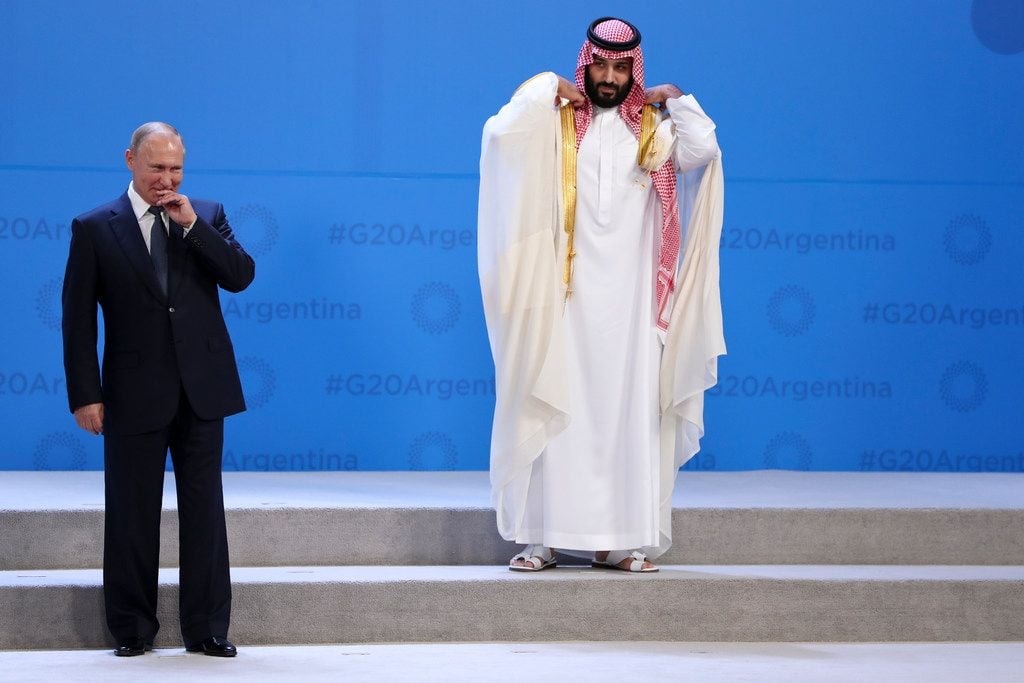 In this Nov. 30, 2018 photo, Russian President Vladimir Putin and Crown Prince Mohammed bin Salman of Saudi Arabia wait for the G20 group photo in Buenos Aires, Argentina. All eyes were on the Saudi crown prince at the Group of 20 summit as he made his first major overseas appearance since the killing of a dissident journalist in his country's consulate in Istanbul.