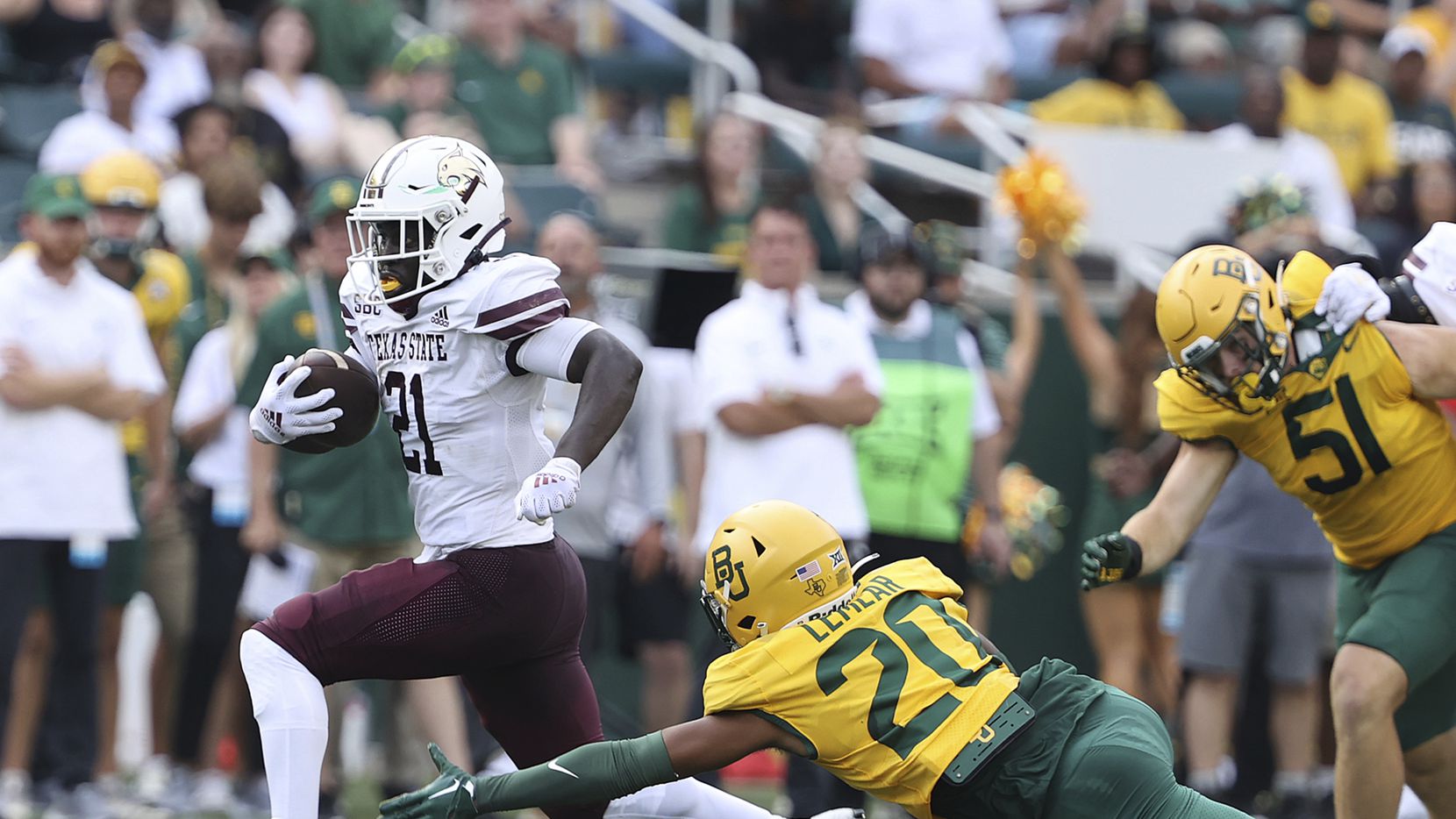 Texas State running back Ismail Mahdi (21) breaks the tackle of Baylor safety Devin Lemear...