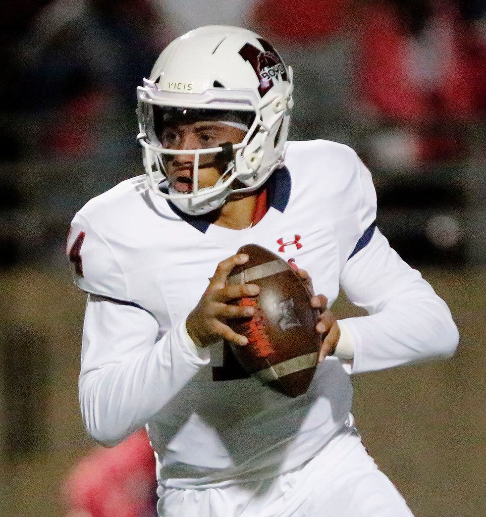 McKinney Boyd High School quarterback Carter Whitefield (14) rolls out of the pocket during...