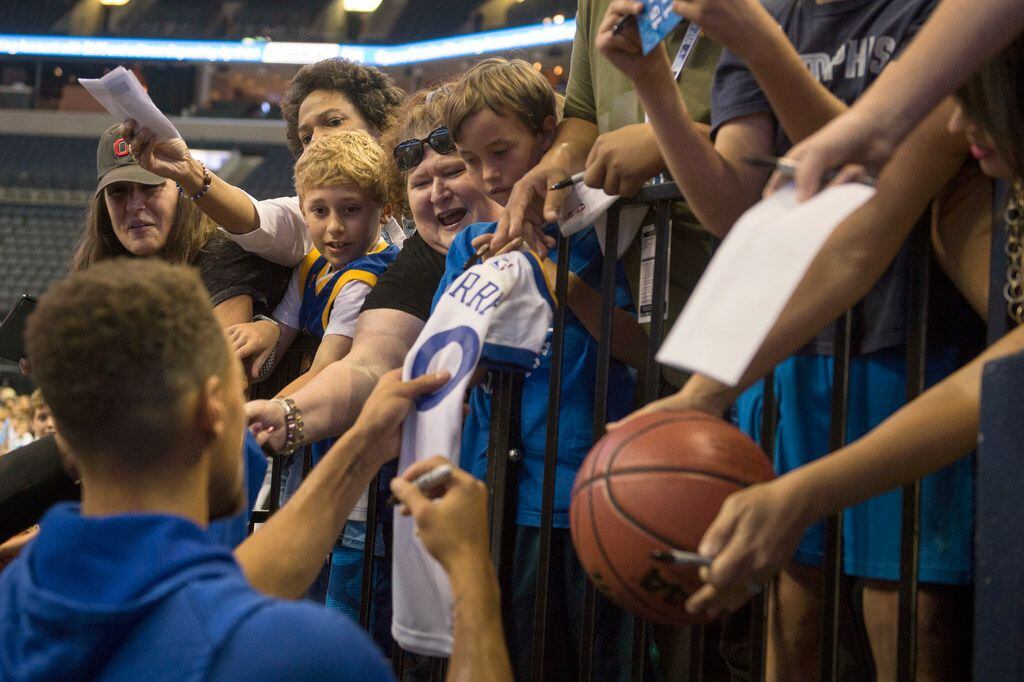 Golden State Warriors guard Stephen Curry, left, signs autographs for fans before an NBA basketball game against the Memphis Grizzlies Saturday, Oct. 21, 2017, in Memphis, Tenn. (AP Photo/Brandon Dill)
