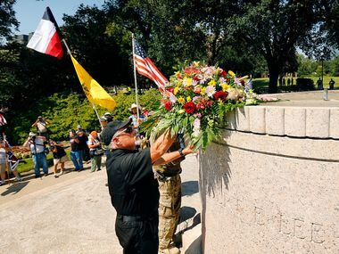 Commanding officer Robert Beverly of the Texas Liberty Coalition places a bouquet of flowers...