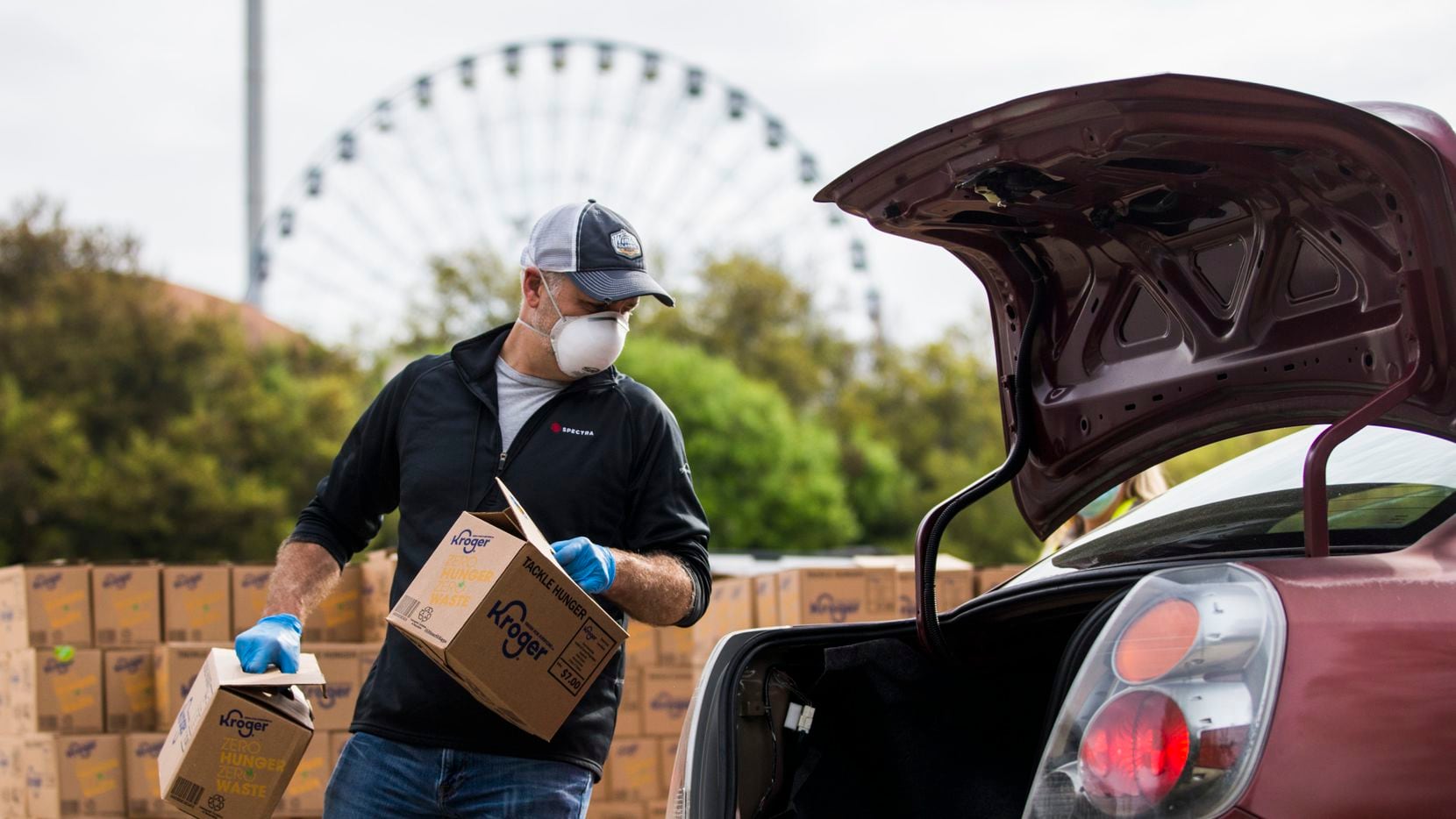 Volunteer Joe Skenderian places boxes of food in the back of a vehicle.