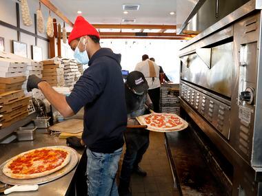 Jalen Holloway, left, puts cheese on a pizza as Jacob Walker, right, puts a pepperoni pizza in the oven at Sfereco in the Statler hotel on Friday, February 19, 2021, in downtown Dallas. The restaurant continued to sell food during the winter storm, when nearly every other restaurant in Dallas closed for at least one day.