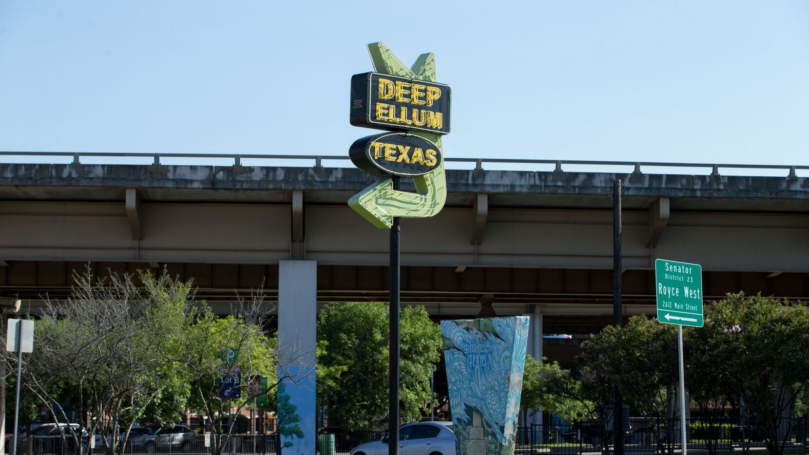 The Deep Ellum, Texas, sign on the corner of Main Street and Good Latimer Expressway points...