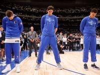 Dallas Mavericks Luka Doncic (left), Boban Marjanovic (center) and Dwight Powell bow their...