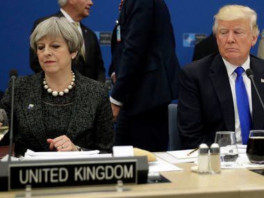 President Trump sits next to British Prime Minister Theresa May during a NATO summit in...