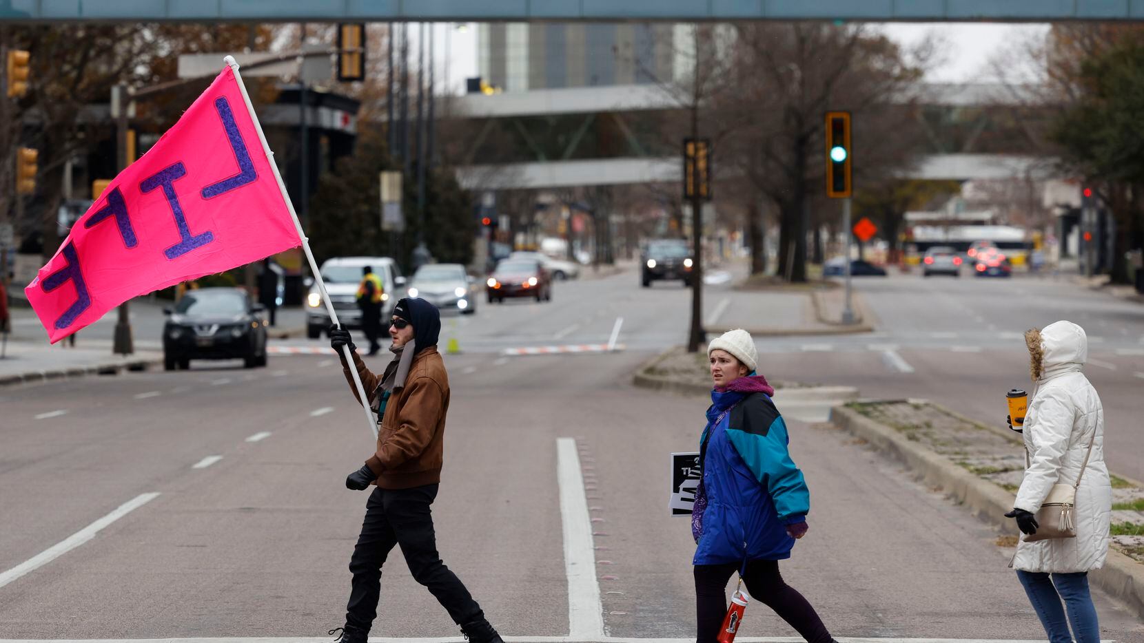 Marchers holding signs walk along Ross Ave. during the North Texas March for Life,...