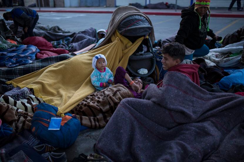 Grupo de migrantes que duermen en el cruce fronterizo que conecta Tijuaja con Estados...