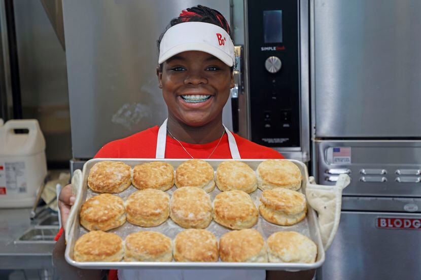 Bojangles employee J’naria Coffey pulls fresh biscuits from the oven in Euless. The store on...