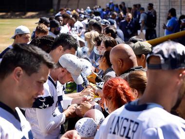 Dallas Cowboys sign autographs for volunteers following their last practice of training camp...