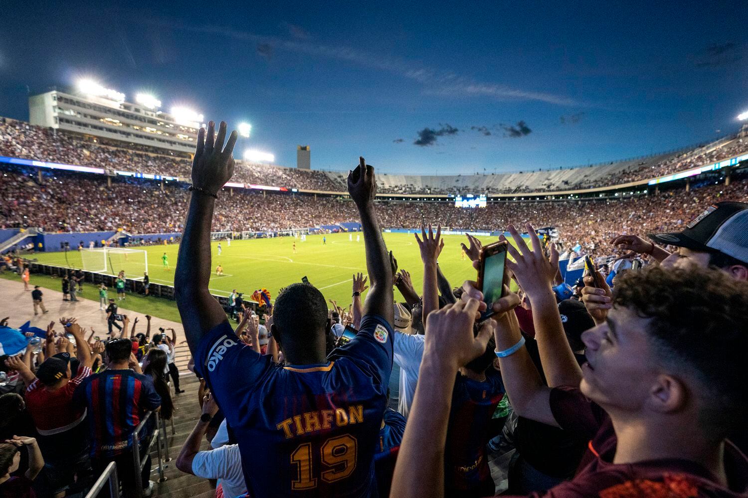 A crowd of over 58,000 fans does the wave during the second half of a soccer match between...