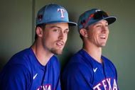 Texas Rangers outfielders Evan Carter and Wyatt Langford look out from the dugout before a...