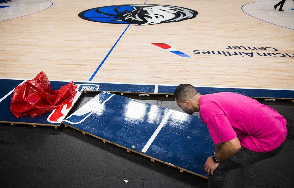 Crews break down the court after the Dallas Mavericks beat the Denver Nuggets 113-97 on...