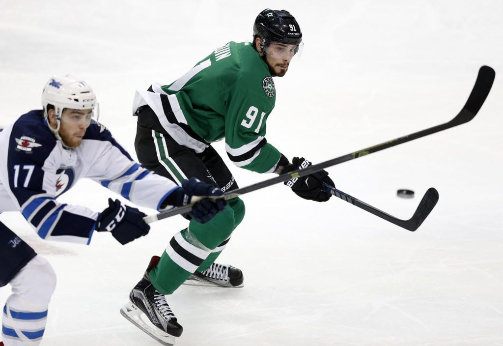 The puck passes by Winnipeg Jets left wing Adam Lowry (17) as Dallas Stars center Tyler Seguin (91) keeps his eyes on the puck to receive it during the second period of play at American Airlines Center in Dallas on Thursday, February 25, 2016. (Vernon Bryant/The Dallas Morning News)