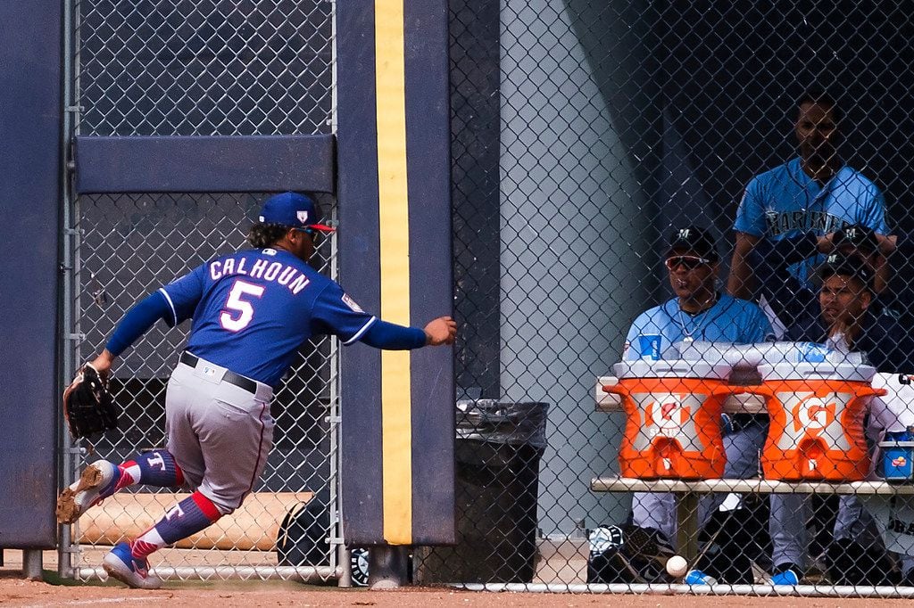 Texas Rangers outfielder Willie Calhoun chase a double off the bat of Seattle Mariners third...