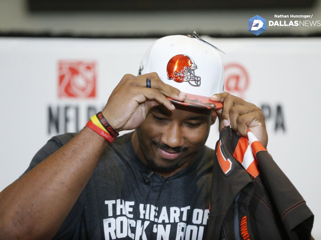 Myles Garrett of Texas A&M and Arlington Martin puts on a Cleveland Browns hat after being...