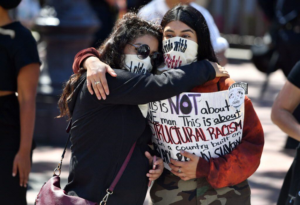 Protesters embrace during a demonstration in San Francisco on Saturday.