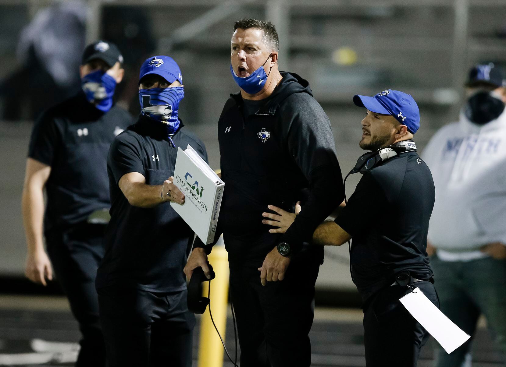 North Forney head coach Randy Jackson, center, is held back by assistant coaches while...