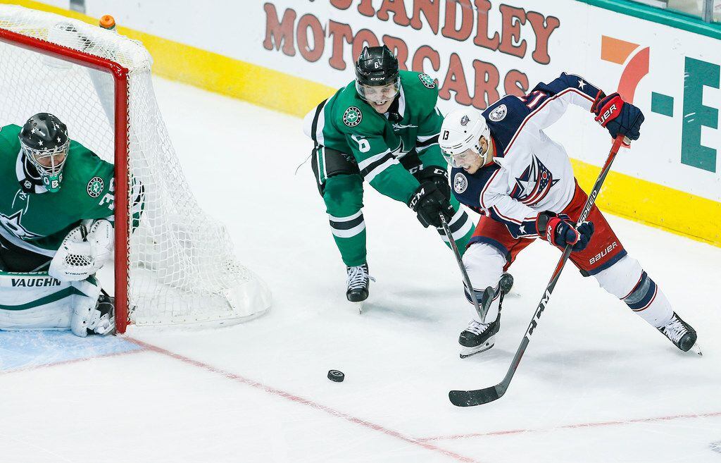 Columbus Blue Jackets forward Cam Atkinson (13) dumps the puck in front of the net as Dallas...