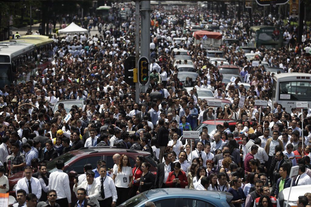 
				La gente evacuada de los edificios de oficinas se reúne en la avenida Reforma después...