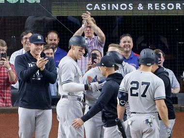 Members of the New York Yankees greet New York right fielder Aaron Judge (99) after he hit...