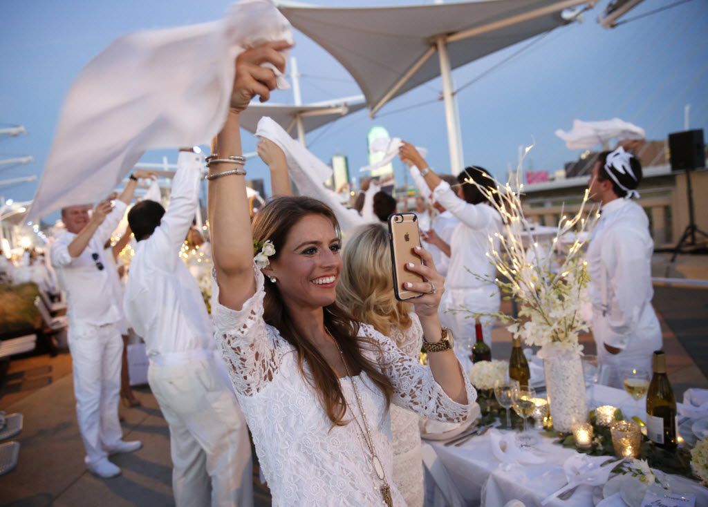 Laura West waves her napkin to signal dinner time during the inaugural Diner en Blanc Dallas...