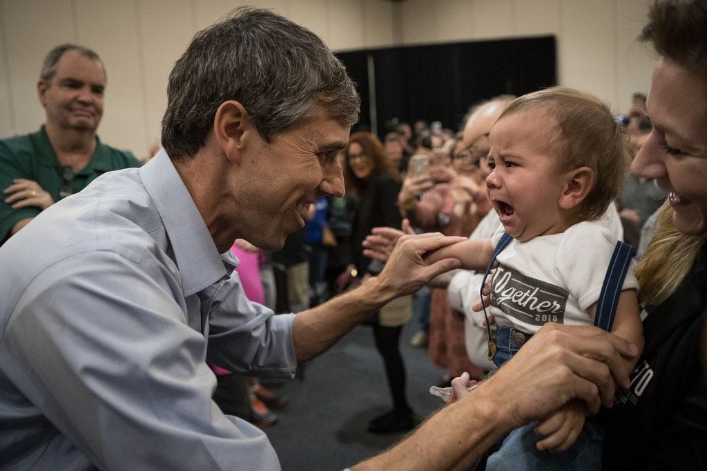 Democratic Senate candidate Beto O'Rourke tries to cheer up a crying baby at a campaign...