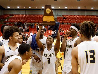 McKinney's Jacovey Campbell (3) holds the championship trophy after beating Arlington...