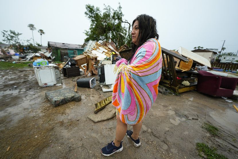 Una mujer está parada afuera de su casa después de que un tornado azotara el sábado 13 de...