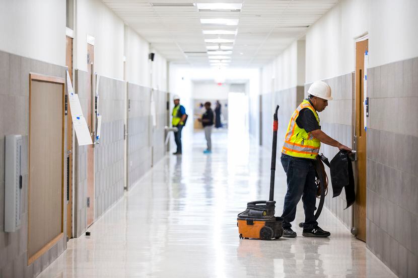 A worker moves cleaning equipment in a hallway on Thursday, December 19, 2019 at South Oak...
