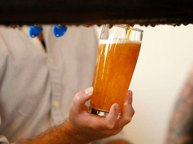 Beer glass is filled for a customer at Family Business Beer Company in Dripping Springs,...