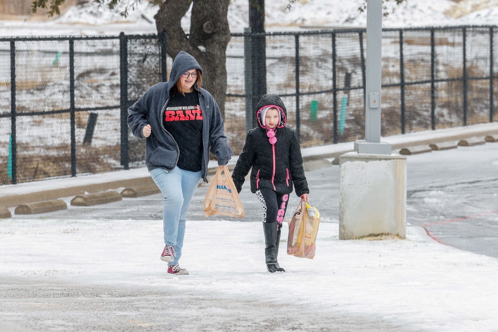 Teagan McDowell, 16, and Rebekkah Andrews, 8, play together as they walk after getting some...