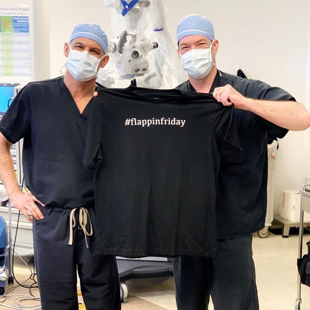 Dr. Jason Potter and Dr. Joshua Lemmon stand together wearing surgical garb and holding a...