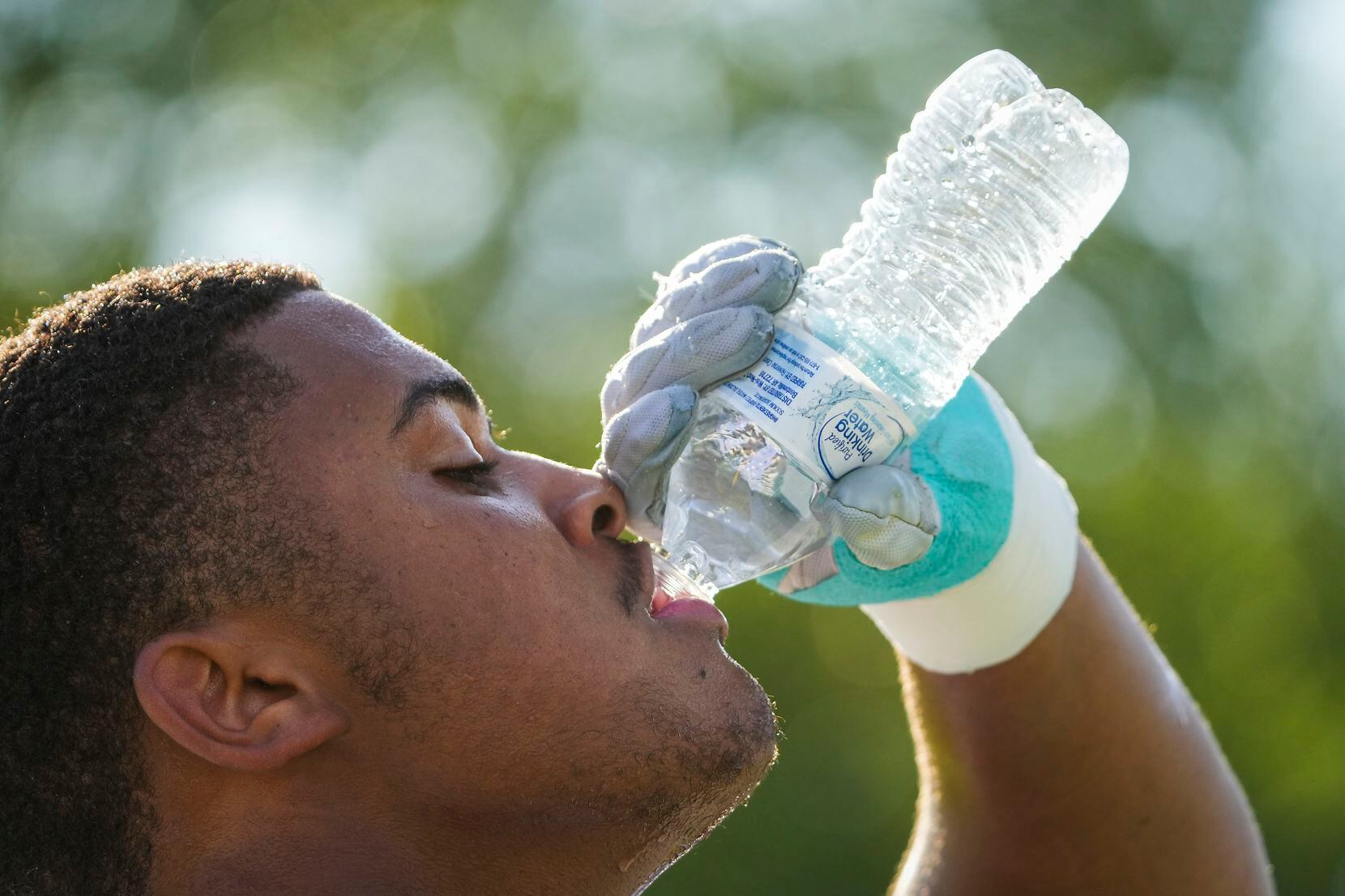Lineman Jordan Smith-Rowe drinks water during the first practice of the season for defending...
