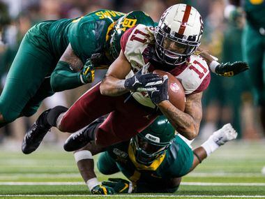Oklahoma Sooners wide receiver Jadon Haselwood (11) is tackled by Baylor Bears cornerback Grayland Arnold (1) and linebacker Jordan Williams (38) during the fourth quarter of an NCAA football game between Baylor University and Oklahoma University on Saturday, November 16, 2019 at McLane Stadium in Waco, Texas. (Ashley Landis/The Dallas Morning News)