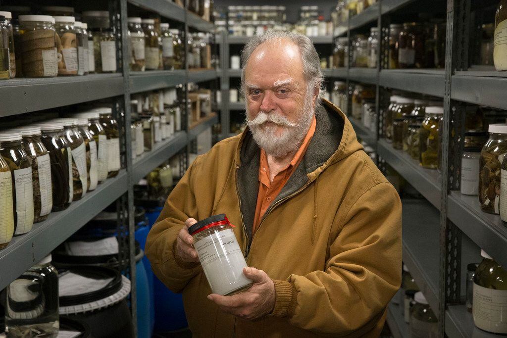 Jonathan Campbell, a biology professor at the University of Texas at Arlington, holds a jar...