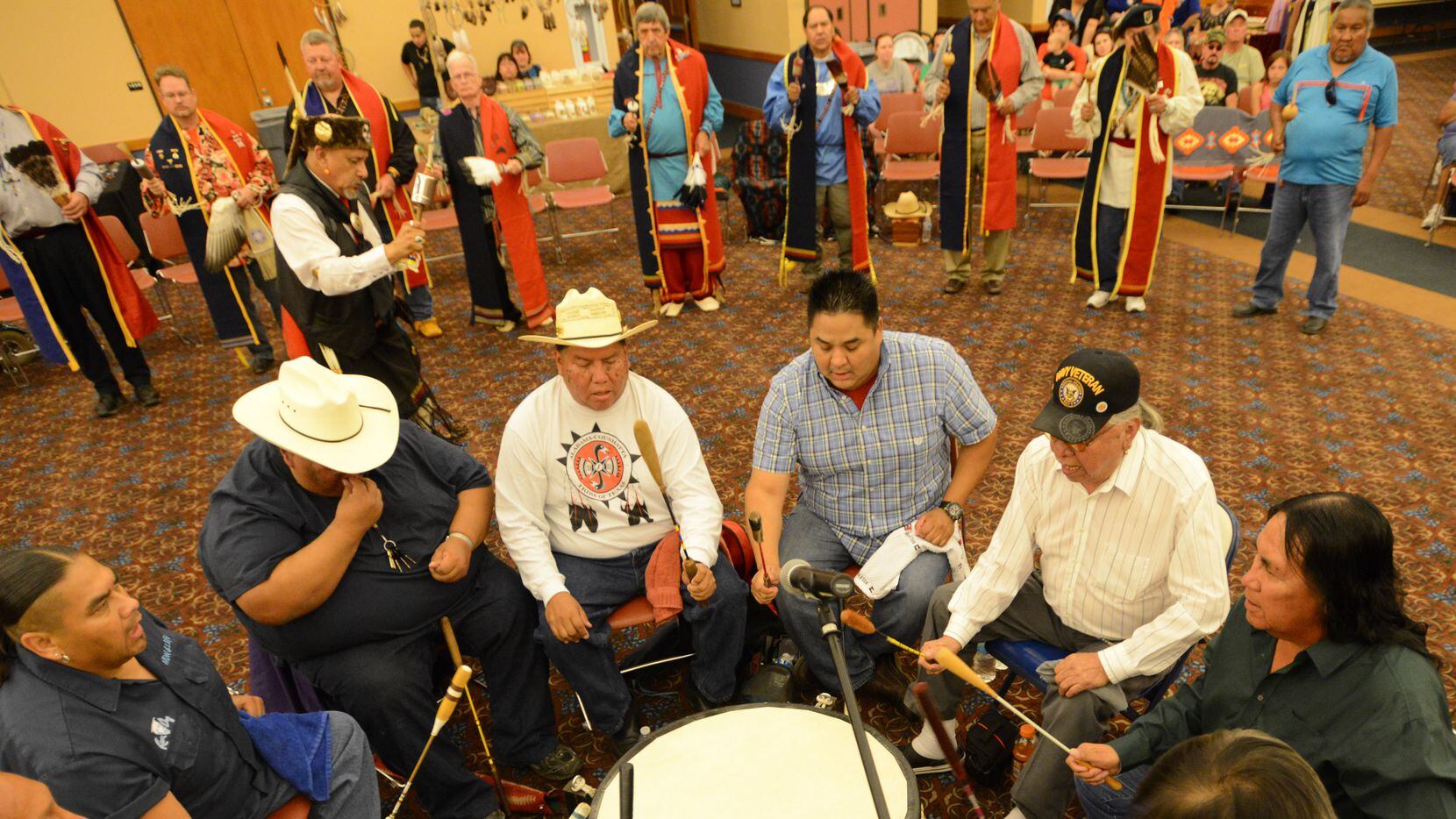 Members of the AC Woodland singers sing and play the drum during the UTA Benefit Powwow in...