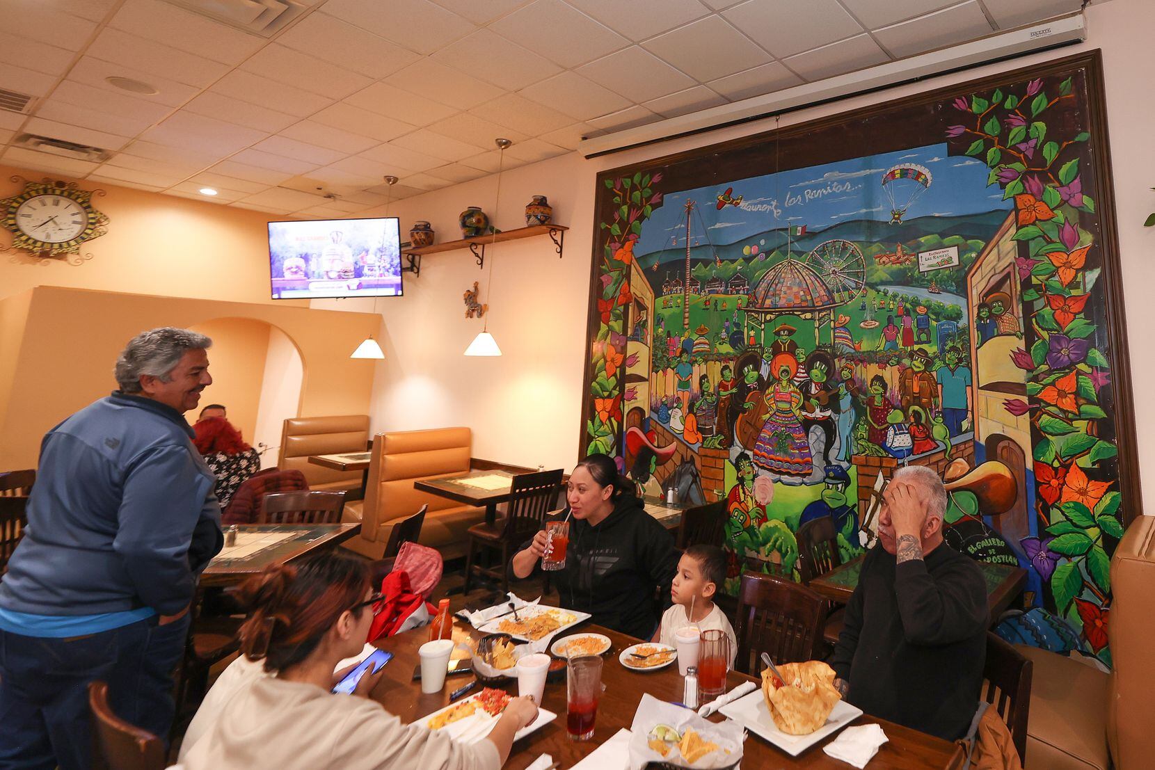 DALLAS, TX- JAN: The owner of the restaurant Las Ranitas, Raul Estrada, greets his friends...