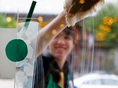 Christina Jackson cleans the windows of new Starbucks  in the Shops at Park Lane, Dallas,...