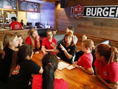 Merile Dault (background center) trains staff at K.T. Burger, a new burger place in Highland...
