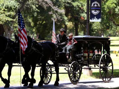 Magnus Ahrens, 8, son of fallen Dallas police officer Lorne Ahrens, rides with the caisson...