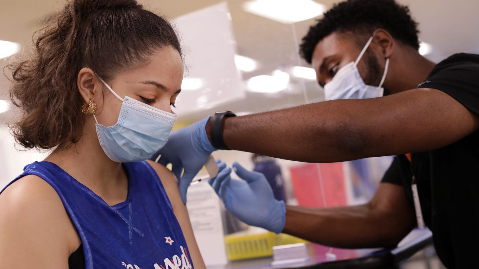 16-year-old Emilia Carreno, left, receives the COVID-19 vaccine from Kendall Payne during a DISD and Parkland Hospital vaccination pop-up clinic at Samuell High School in Dallas, TX, on Jun. 28, 2021.
