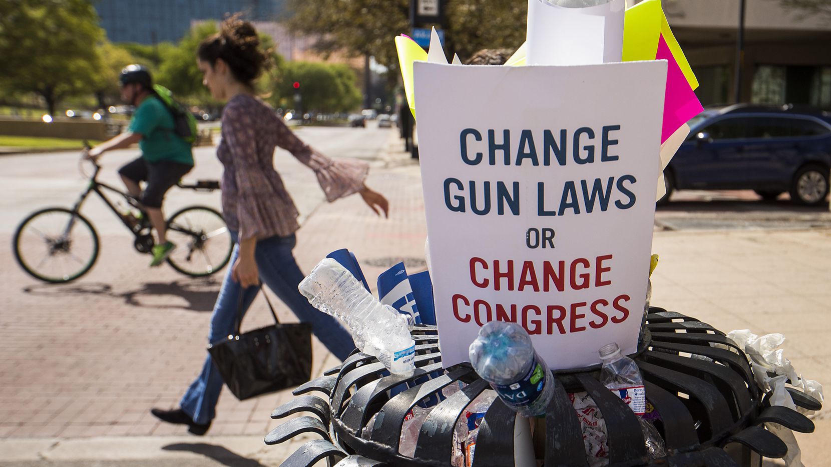 Protest signs and water bottles fill a sidewalk trash bin after a rally and march in support...