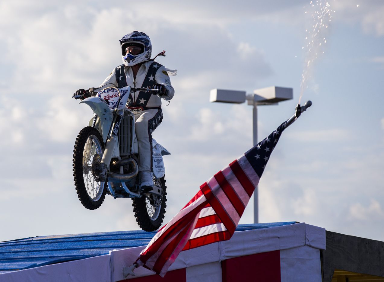 Daredevil Robbie Knievel jumps over 18 Corvettes on a motorcycle during a celebration and...
