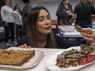 Judge Soraya Spencer, owner and chef at Gather Kitchen, examines some cookie bars during the 24th annual Holiday Cookie Contest hosted by The Dallas Morning News.