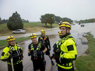 Members of the Mesquite Fire Department survey the flooded area of Interstate 635 Service...