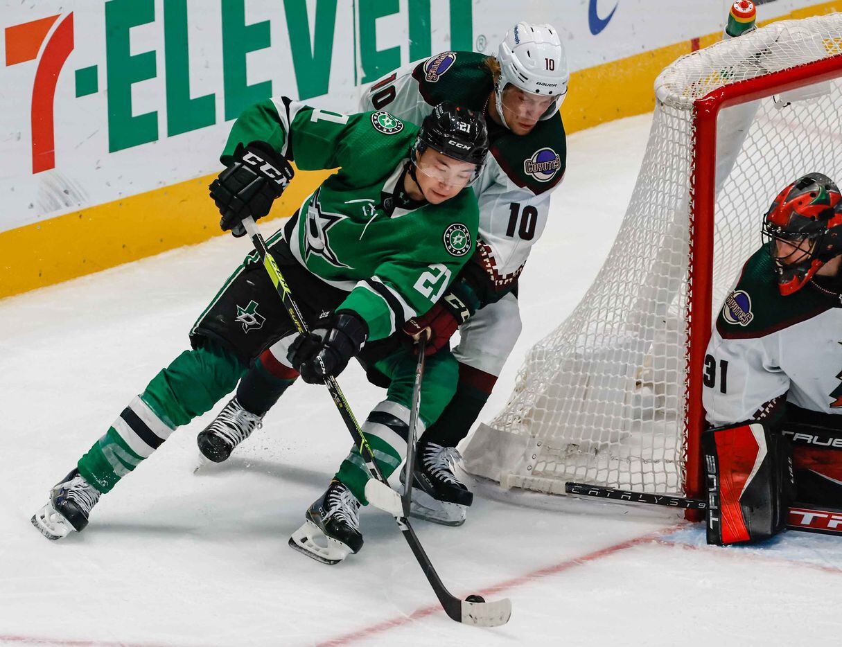 Dallas Stars left wing Jason Robertson (21) goes around Arizona Coyotes center Ryan Dzingel (10) with the puck as goaltender Scott Wedgewood (31) protects the net during third period at the American Airlines Center in Dallas on Monday, December 6, 2021. (Lola Gomez/The Dallas Morning News)