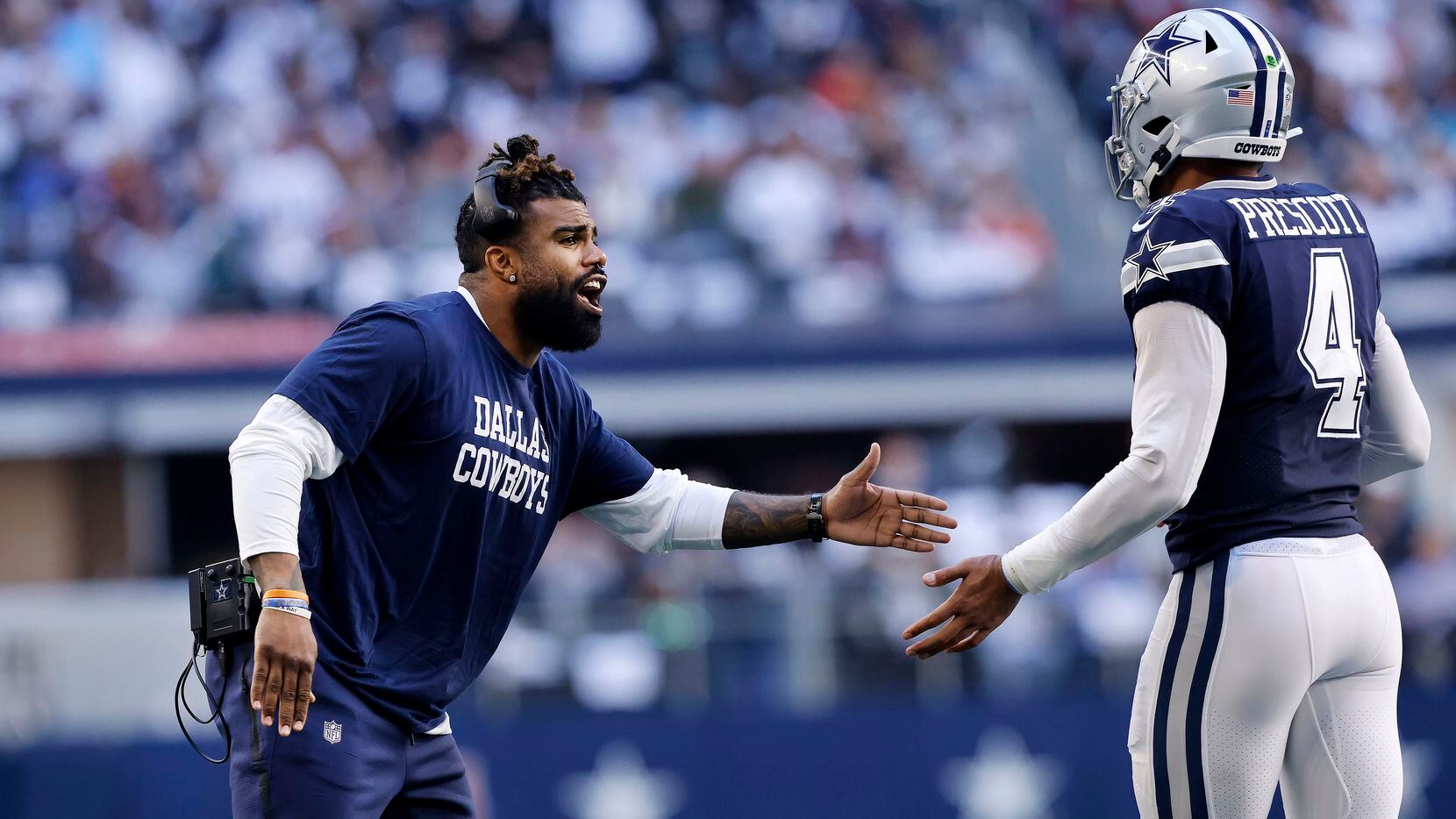 Injured Dallas Cowboys running back Ezekiel Elliott (left) congratulates quarterback Dak...
